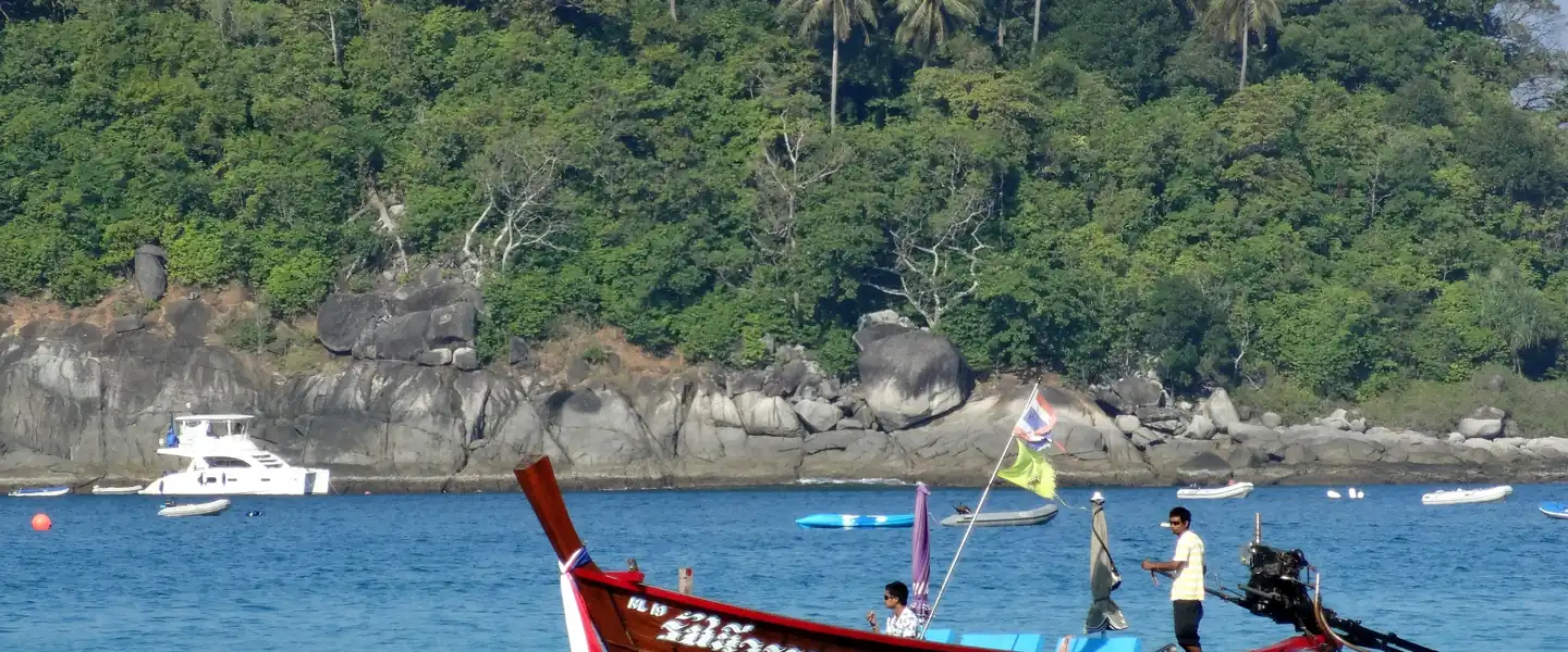A longtail off the rocks at the southern end of Kata · Mikhail Deynekin, CC BY-SA 3.0